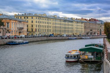 Neva Nehri kıyısında ki sahil binaları ve St. Petersburg'da su üzerinde turistik tekneler