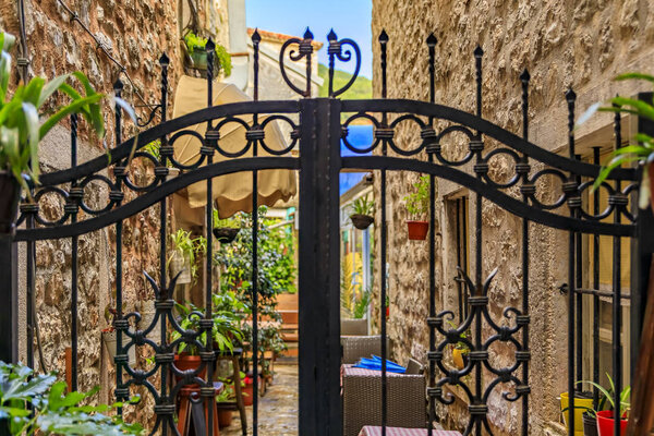 Wrought iron gate in the narrow streets of the medieval Old town with shops, cafes and restaurants in Budva, Montenegro in the Balkans