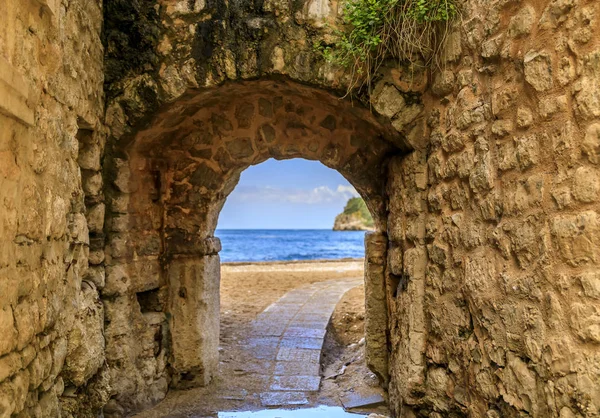 Picturesque brick arch and path of the medieval Old town open onto the Adriatic Sea in the Balkans in Budva, Montenegro