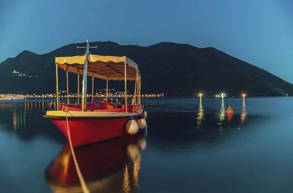 Vista del atardecer naranja y verde azulado de la bahía de Kotor y un barco atracado en la ciudad perfecta postal de Perast Montenegro — Foto de Stock