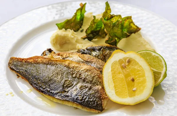 Pan seared branzino or sea bass with mashed potatoes and deep fried kale chips at an al fresco restaurant in Montenegro — Stock Photo, Image