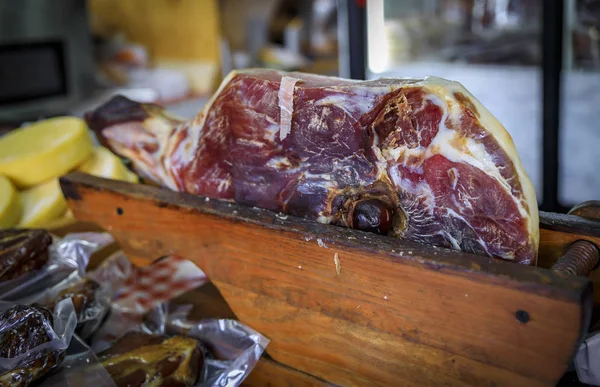 Whole bone-in ham leg of Montenegrin Njeguski prsut cured ham and sliced packaged meat at a market in Kotor Montenegro — Stock Photo, Image