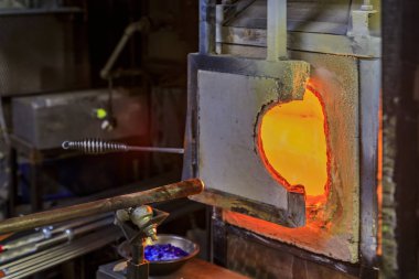 Cam üfleme fırını ve çeşitli cam üfleme aletleri ile masa bir cam üreticisi atölyesinde süreç için kurulmuş