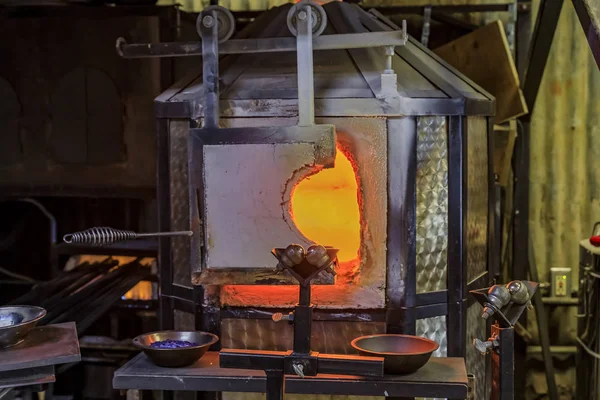 Horno de soplado de vidrio y mesa con varias herramientas de soplado de vidrio en el taller de un fabricante de vidrio configurado para el proceso —  Fotos de Stock