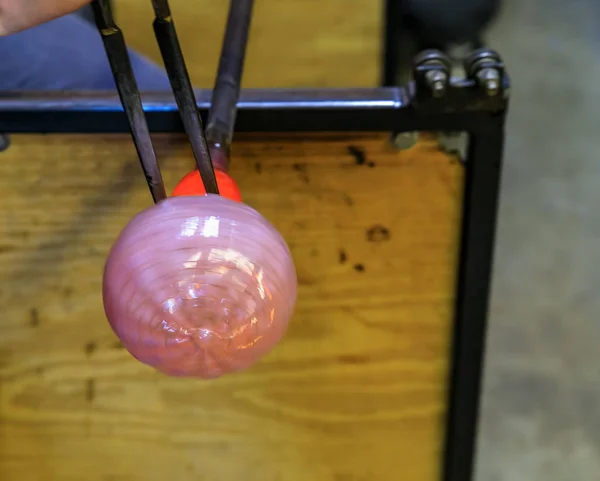 Soprador de vidro moldando uma bolha de vidro derretido em uma haste à mão na oficina de um fabricante de vidro, profundidade rasa de campo — Fotografia de Stock