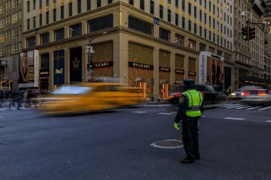 Bulanık sarı taksiler Manhattan, New York, ABD 5th Avenue üzerinde yoğun bir geçiş insanlar ve trafik polisi geçmiş hız