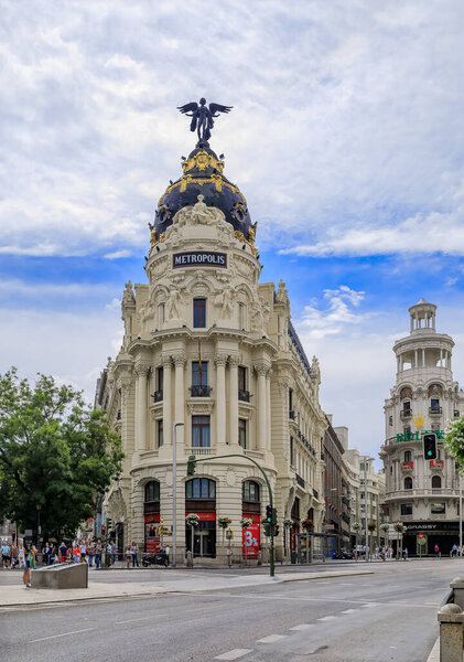 Madrid, Spain - June 4, 2017: View of Metropolis, one of the most beautiful buildings and Gran Via main shopping street with dramatic blue sky