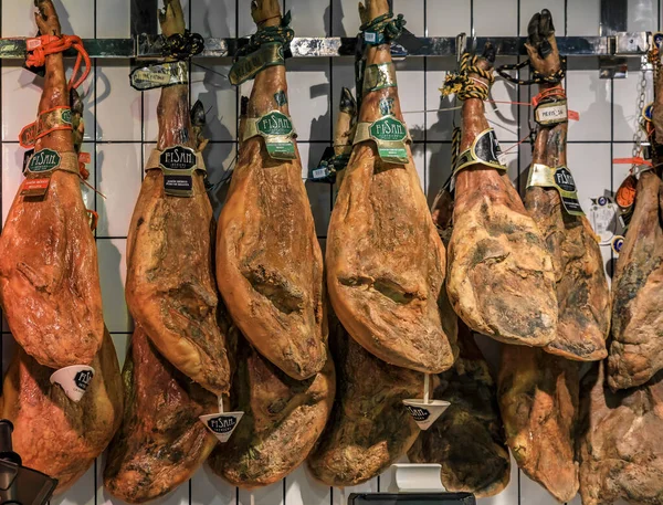 Piernas enteras de jamón serrano iberico en exhibición en un mercado local en Madrid, España —  Fotos de Stock