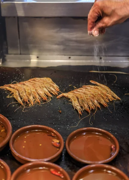 Traditional gambas a la plancha or grilled shrimp tapas being cooked on a hot plate in Madrid, Spain — Stock Photo, Image