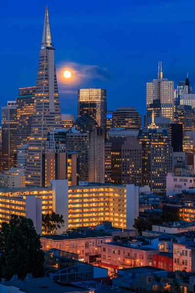 San Francisco downtown skyline at sunset with the full moon between the skyscrapers viewed from Ina Coolbirth park