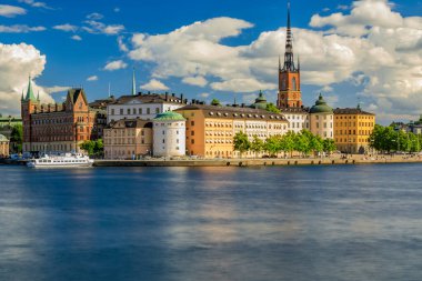 Malaren Gölü 'nün karşısındaki geleneksel gotik binaların panoramik manzarası, eski kasaba, Gamla Stan ve Riddarholmen kilisesi, İsveç' in Stockholm kentindeki İsveç hükümdarlarının defin kilisesi.