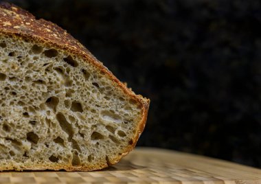 Dilimlenmiş taze fırınlanmış bir somun ekmeği kepçe tahtada koyu çavdar ekmeği ve çavdar ekmeği, evde pişirilmiş fotoğraf serisi.