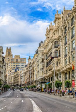 Madrid, İspanya - 5 Haziran 2017: Meşhur Gran Via 'daki güzel binalar, ana alışveriş caddesinde şehir merkezinde yürüyen insanlar.
