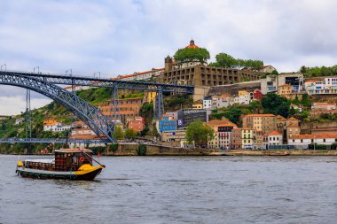 Douro nehri ve I. Dom Luis köprüsünü Vila Nova de Gaia 'da ve Porto, Portekiz' de porto şarabı taşımak için kullanılan turist teknelerini izleyin.