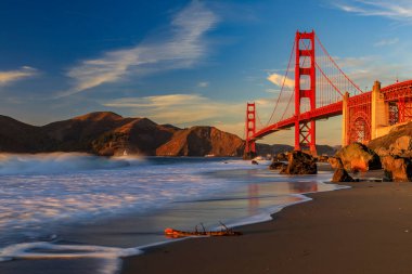 Golden Gate Köprüsü, San Francisco, Kaliforniya 'da gün batımında gizli ve tenha Rocky Marshalls Sahili manzaralı.