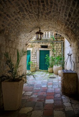 Karadağ 'ın Balkanlarda bulunan Kotor kentindeki iyi korunmuş eski ortaçağ kasabasının sokaklarında resimli alçak taş kemer yolu