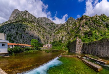 Kotor Körfezi 'nin zümrüt yeşili suları veya Boka Kotorska, dağlar ve eski Kotor kasabasının antik taş şehir duvarı Karadağ' daki eski Venedik kalesi