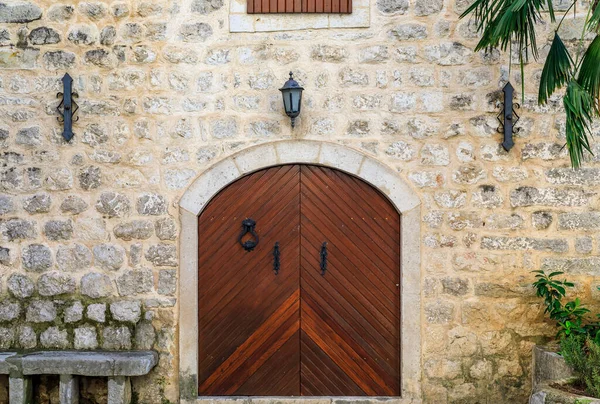 Picturesque wooden gate of an old stone house in the well preserved medieval Old town Kotor, Montenegro in the Balkans
