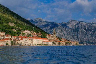 Dünyaca ünlü Kotor Körfezi 'nde yer alan tarihi Perast kasabasının manzaralı manzarası, güneşli bir günde arka planda dağlar, Karadağ
