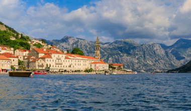 Dünyaca ünlü Kotor Körfezi 'nde yer alan tarihi Perast kasabasının manzaralı manzarası, güneşli bir günde arka planda dağlar, Karadağ