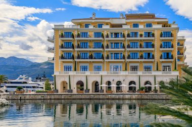 Tivat Karadağ 'ın arka planında lüks konut binaları ve botlarla Adriyatik Denizi marinasının manzarası