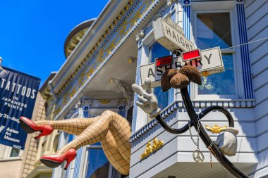 San Francisco, ABD - 4 Temmuz 2019: İkonik heykel balıkçı çorabı giymiş kadın bacakları ve Haight Ashbury mahallesindeki bir pencerede kırmızı topuklu ayakkabılar