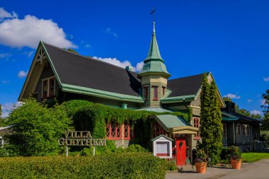 Stockholm, İsveç - 11 Ağustos 2017: 19. yüzyılda Curgarden adasında nehir manzaralı gotik bir ahşap binada Villa Godthem gurme yemeği