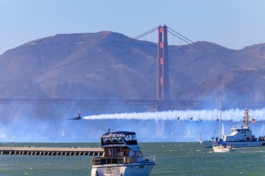 San Francisco, ABD - 7 Ekim 2017: Patriots Jet Takımı Aerobatik Takımı Aero L-39 Albatros jeti, Golden Gate Köprüsü 'nün altında renkli zıtlıklarla uçuyor