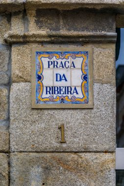 Portekiz 'in ünlü Ribeira Meydanı Porto' sunun ön cephesinde süslü azulejo fayanslarıyla Praca da Ribeira 1 sokak tabelası.