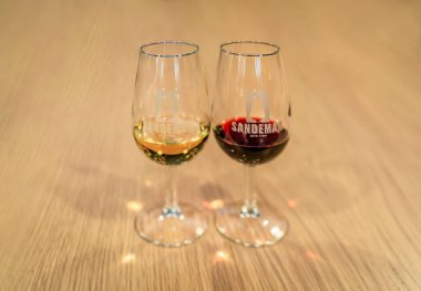 Porto, Portekiz - 31 Mayıs 2018: Sandeman mahzeninde tadımlık iki bardak yakut ve beyaz şarap, 1790 yılında Vila Nova de Gaia 'da kurulan popüler marka.