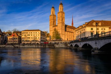 Altstadt 'taki Limmat Nehri üzerinde klasik binalar ve ikiz ikiz Grossmunster Roma katedrali, Zürih, İsviçre
