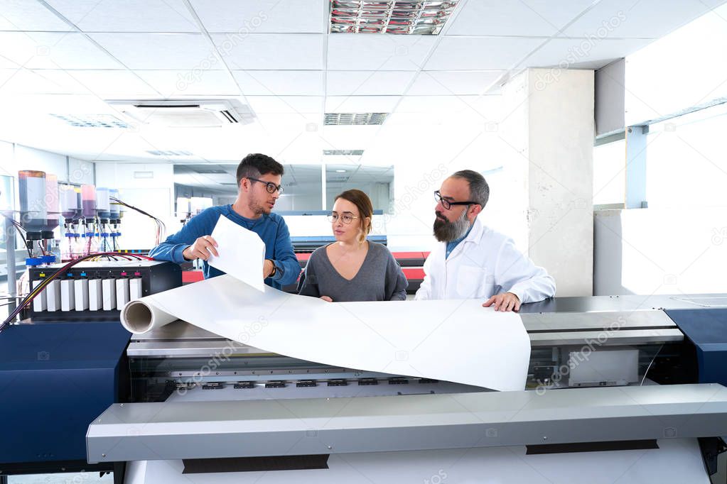 Printing team at industry plotter printer men and woman