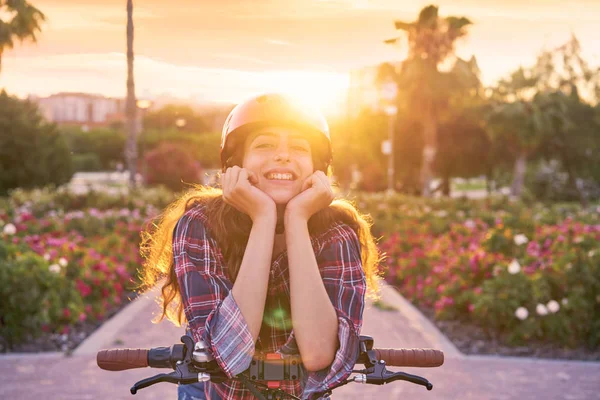 笑顔の花で幸せなヘルメットと自転車の少女の肖像画を屋外駐車します — ストック写真