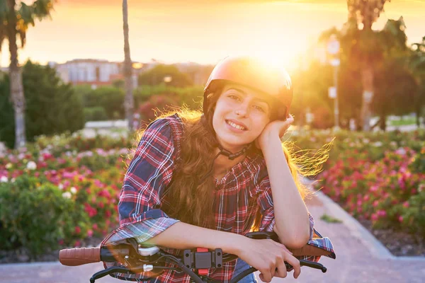 笑顔の花で幸せなヘルメットと自転車の少女の肖像画を屋外駐車します — ストック写真