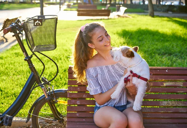 屋外芝生草の背景と公園のベンチに座っている犬を持つ少女 — ストック写真