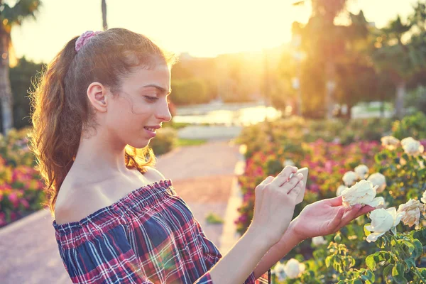 Smarphone とバラの花を撮影する少女の肖像画 — ストック写真