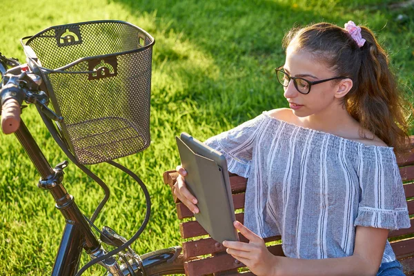 Girl Sitting Park Bench Playing Tablet Bike — Stock Photo, Image