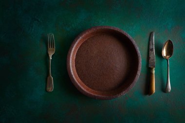 Seramik sofra seramik plaka üzerinde grunge yeşil renkli vintage çatal bıçak takımı