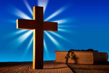 Ahşap çarmıhta Hıristiyan İncil ve tespih boncuklar ile yapılan mavi gökyüzü ahşap