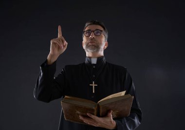 Rahip erkek cennet gökyüzü kadar İncil'i işaret parmağı holding