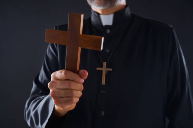 Ahşap ön planda dua çapraz tutarak rahip