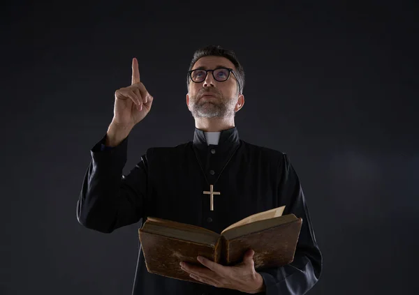 Священник Мужского Пола Держит Библию Указывая Пальцем Вверх Небо — стоковое фото