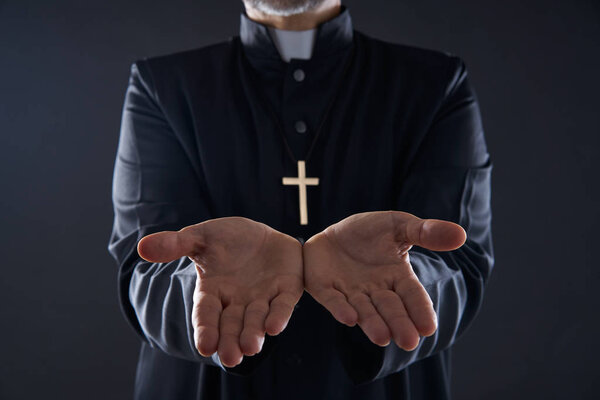 Священник с распростертыми руками молится, принося жертву
