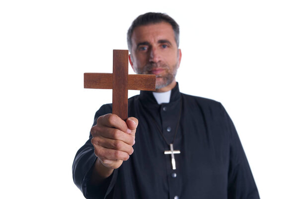 Priest holding cross of wood praying in foreground