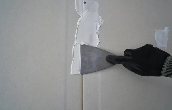 层压石膏板抹灰连接细节铲子和手 — 图库照片