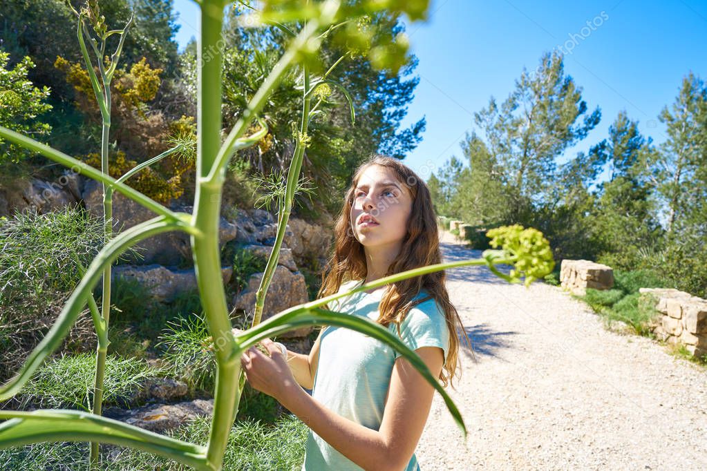 Brunette teen girl in Mediterranean track with fennel plants