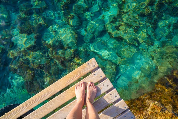 Ibiza piernas de niña en la playa de Portinatx agua clara —  Fotos de Stock