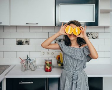 Mutfaktaki blender 'da taze meyve suyu ya da yemek yapan mutlu genç kız. Meyve suyu çıkarıcı. Sağlıklı beslenme konsepti, vitaminler.