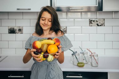 Modern mutfakta meyveleri olan mutlu bir ev hanımı. vejetaryen yemeği