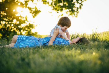 Huysuz anne ve yakışıklı oğul doğada eğleniyor. Mutlu aile kavramı. Aile hayatı olan güzel doğa manzarası. Mutlu bir aile birlikte dinleniyor. Aile yaşamında mutluluk. Anneler Günü.